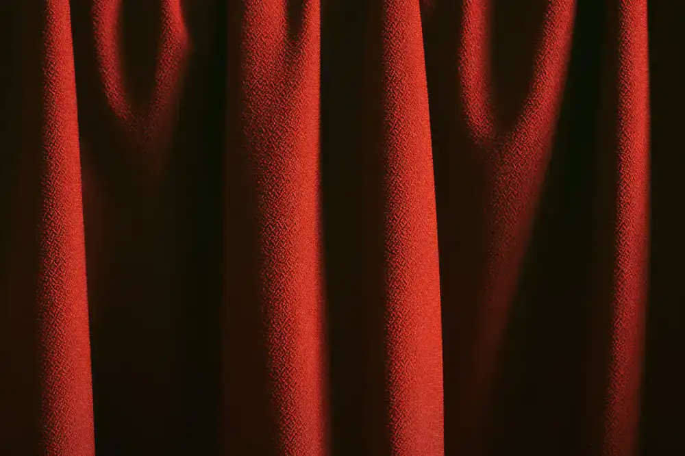 Textured dark background resembling heavy theater curtains