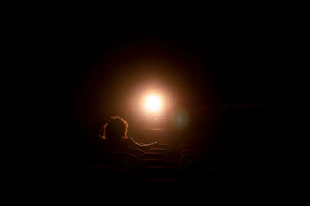 Stage spotlight shining on an empty velvet chair