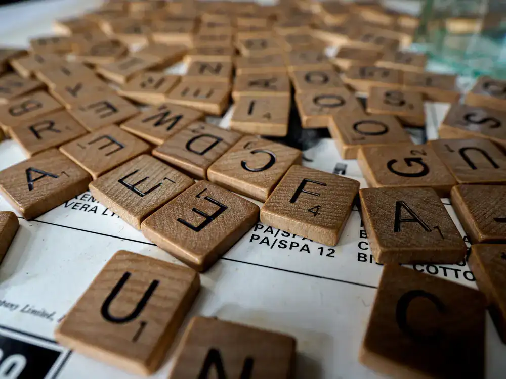 A crystal glass and scattered letters on a wooden table